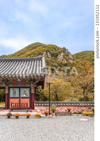 The entrance to Jangansa Temple in Gijang, Busan, South Korea, with autumnal scenery of mountains and persimmon trees. Blue sky. 131952112