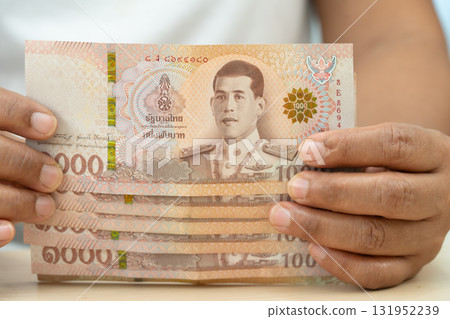 Asian woman holding Thai banknotes money, economy finance exchange trade investment. 131952239