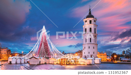Vilnius, Lithuania. Christmas Tree On Background Bell Tower Belfry Of Vilnius Cathedral At Cathedral Square In Evening New Year Christmas Xmas Illuminations. Unesco World Heritage Site. Altered Sky Vilnius, Lithuania. Christmas Tree On Background Bell Tower Belfry Of Vilnius Cathedral At Cathedral Square In Evening New Year Christmas Xmas Illuminations. Unesco World Heritage Site. Altered Sky 131952367