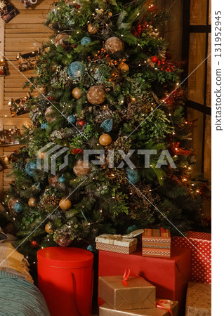Decorated Christmas tree with lights and ornaments. Festive holiday interior decoration for celebration greeting card. Decorated Christmas tree with lights and ornaments. Festive holiday interior decoration for celebration greeting card. 131952945