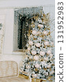 Decorated Christmas tree with golden ornaments and gifts in a festive room interior, on an inviting rug, for holiday season 131952983