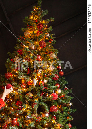 Decorated Christmas tree with glowing string lights and festive ornaments. Holiday season celebration decoration for Winter. Decorated Christmas tree with glowing string lights and festive ornaments. Holiday season celebration decoration for Winter. 131952996