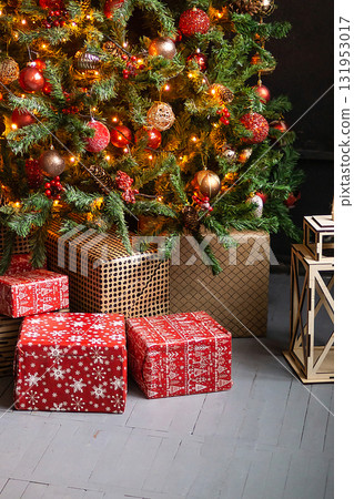 Christmas tree decorated with festive ornaments and glowing lights, with holiday presents on the floor. Winter celebration and seasonal decor concept. Christmas tree decorated with festive ornaments and glowing lights, with holiday presents on the floor. Winter celebration and seasonal decor concept. 131953017