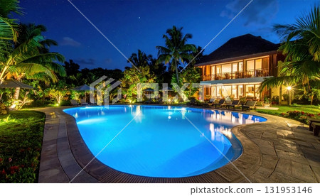 Luxury resort swimming pool with tropical palm trees reflecting in the dark night water 131953146