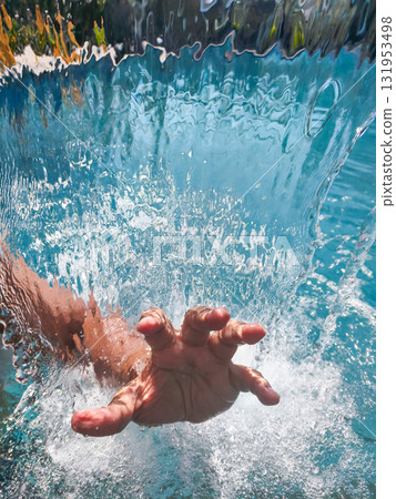 Underwater view of a hand reaching for the surface amidst bubbles and light. Underwater view of a hand reaching for the surface amidst bubbles and light. 131953498