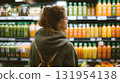 Woman looking at colorful juice bottles at a grocery store. Choosing a healthy beverage. Fresh ingredients on display. Healthy and refreshing lifestyle. 131954138