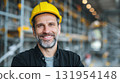 Construction Worker: Smiling man wearing a safety hard hat, ready for work in industrial setting. Confident, experienced and prepared for the day. 131954148