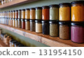Spice Rack: Variety of colorful ground spices, seasonings in glass jars on a wooden shelf. Culinary herbs and spices. 131954150
