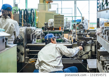 A group of workers operating machine tools in a factory 131954571