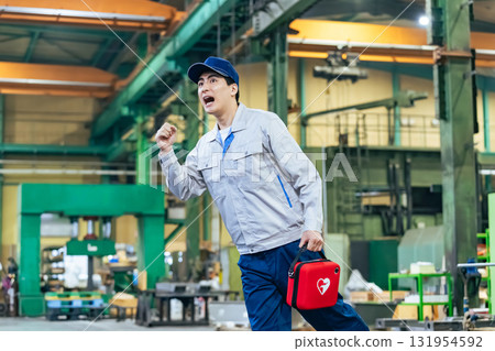 一名男工人拿著 AED 奔跑 一名男工人拿著 AED 奔跑 131954592