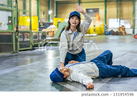 A female worker rescues a worker who collapsed at a factory 131954596