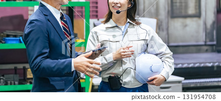 一名男商人和一名女工人視察工廠 131954708