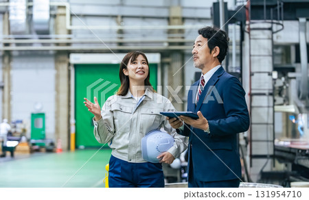 一名男商人和一名女工人視察工廠 131954710