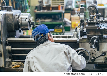 Worker operating machine tools in a factory 131954730