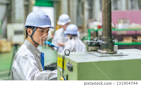 一名男工人在工廠的控制面板上操作機器 131954744