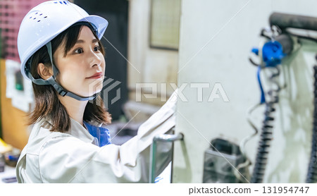 Female worker operating factory machinery 131954747