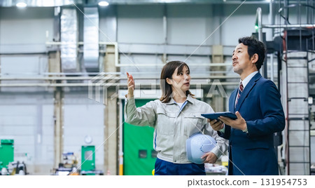 一名男商人和一名女工人視察工廠 131954753