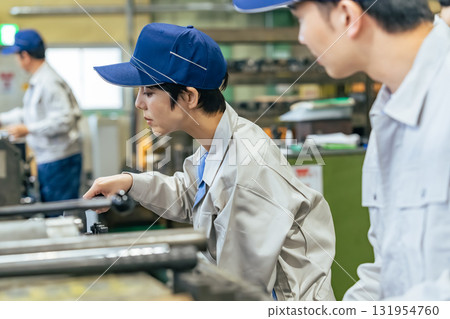 Group of workers operating machines in a factory Group of workers operating machines in a factory 131954760