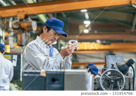Male worker inspecting products at a factory 131954766