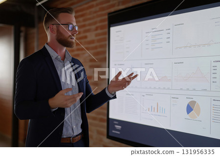 Businessman is gesturing while presenting business growth on a digital screen during a meeting Businessman is gesturing while presenting business growth on a digital screen during a meeting 131956335