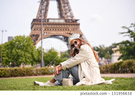Stylish woman sitting near Eiffel Tower in Paris  131956638