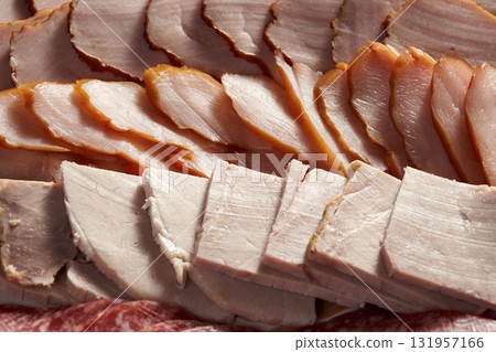 A variety of meats are sliced and arranged on a plate A variety of meats are sliced and arranged on a plate 131957166
