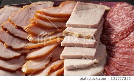 A plate of meat and cheese with a slice of ham on top 131957235