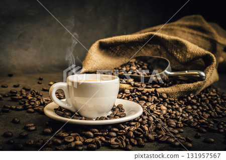 Steaming coffee cup with roasted beans 131957567
