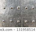 Close up background texture of an old, riveted metal door. strong, antique iron surface with rough, weathered pattern creates an imposing feeling of ancient protection 131958514