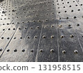 Close up view of an industrial metal plate floor with dark rivet pattern. This strong steel texture makes great background, showing durable and historic surface 131958515