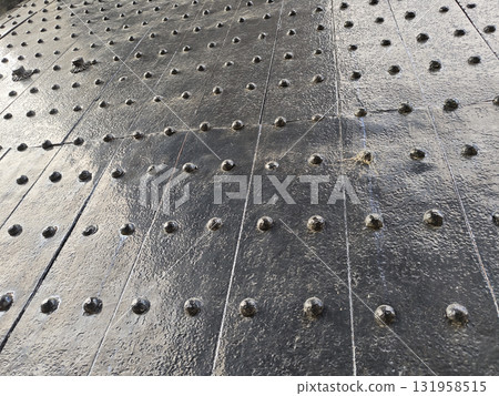 Close up view of an industrial metal plate floor with dark rivet pattern. This strong steel texture makes great background, showing durable and historic surface Close up view of an industrial metal plate floor with dark rivet pattern. This strong steel texture makes great background, showing durable and historic surface 131958515