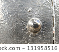Rugged industrial close up detail of black metal rivet on textured iron surface. This strong and powerful background shows weathered, antique feeling 131958516