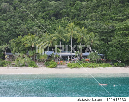 Fitzroy Island – a white sand cove lined with palm trees and huts 131958580