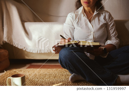 Cozy Home Writing Session: Woman Journaling With Notebook And Cup In Living Room 131959997