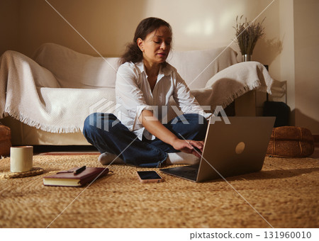 Woman Working On Laptop From Cozy Living Room On Soft Rug 131960010
