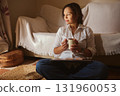 Relaxed Woman With Coffee Mug Working On Laptop In Cozy Living Room 131960053