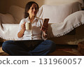 Relaxed Woman At Home Using Phone With Coffee Mug While Sitting On The Floor Cozy Moment 131960057