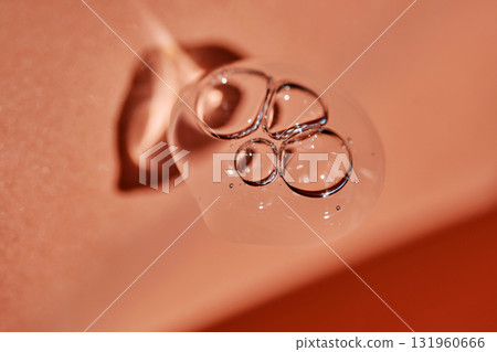 A drop of cosmetic product on a terracotta background. A drop of cosmetic product on a terracotta background. 131960666