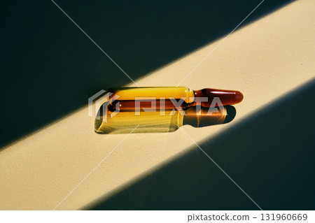 A ampoule with a medical product in a beam of bright light. 131960669