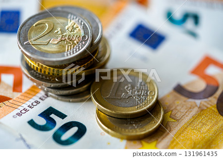 Euro coins on 50 euro banknotes representing European currency, finance, economy, and savings 131961435