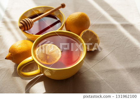 Flat Lay with Lemon Tea and Honey on Light Table under Sun Light 131962100