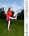 Young Woman Practicing Soccer Skills Outdoors on a Sunny Day in Sportswear 131962225
