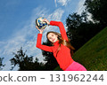 Energetic Young Woman Playing Outdoor Soccer in Bright Red Sportswear 131962244
