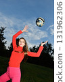 Young Woman in Bright Clothes Playing with a Ball Outdoors on a Sunny Day 131962306