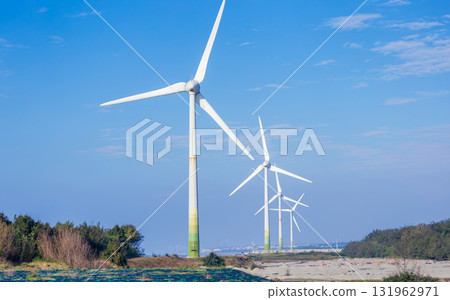 White wind turbines stand on the coast 131962971