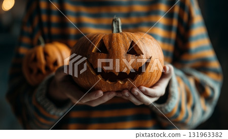 Holding Carved Pumpkins During Halloween Celebration in a Cozy Indoor Setting Holding Carved Pumpkins During Halloween Celebration in a Cozy Indoor Setting 131963382