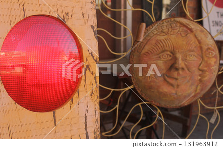 Red Light Next to a Sun and Moon Decoration at Thrift Shop Red Light Next to a Sun and Moon Decoration at Thrift Shop 131963912