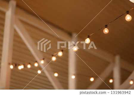 Warm string lights hanging under wooden ceiling with copy space 131963942
