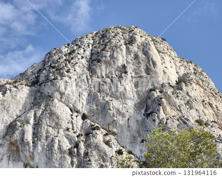 Majestic Rocky Mountain Peak Beneath a Stunningly Clear Blue Sky Enveloping It All 131964116