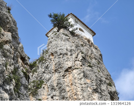 Stunning Clifftop View Featuring a Small White Building Surrounded by Lush Nature Scenery Stunning Clifftop View Featuring a Small White Building Surrounded by Lush Nature Scenery 131964126